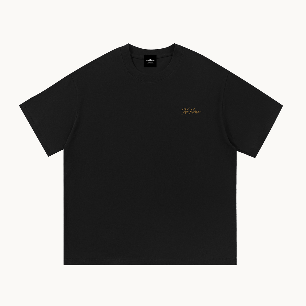 Essential Signature Tee in black, front view with small gold No Noise script at the left chest