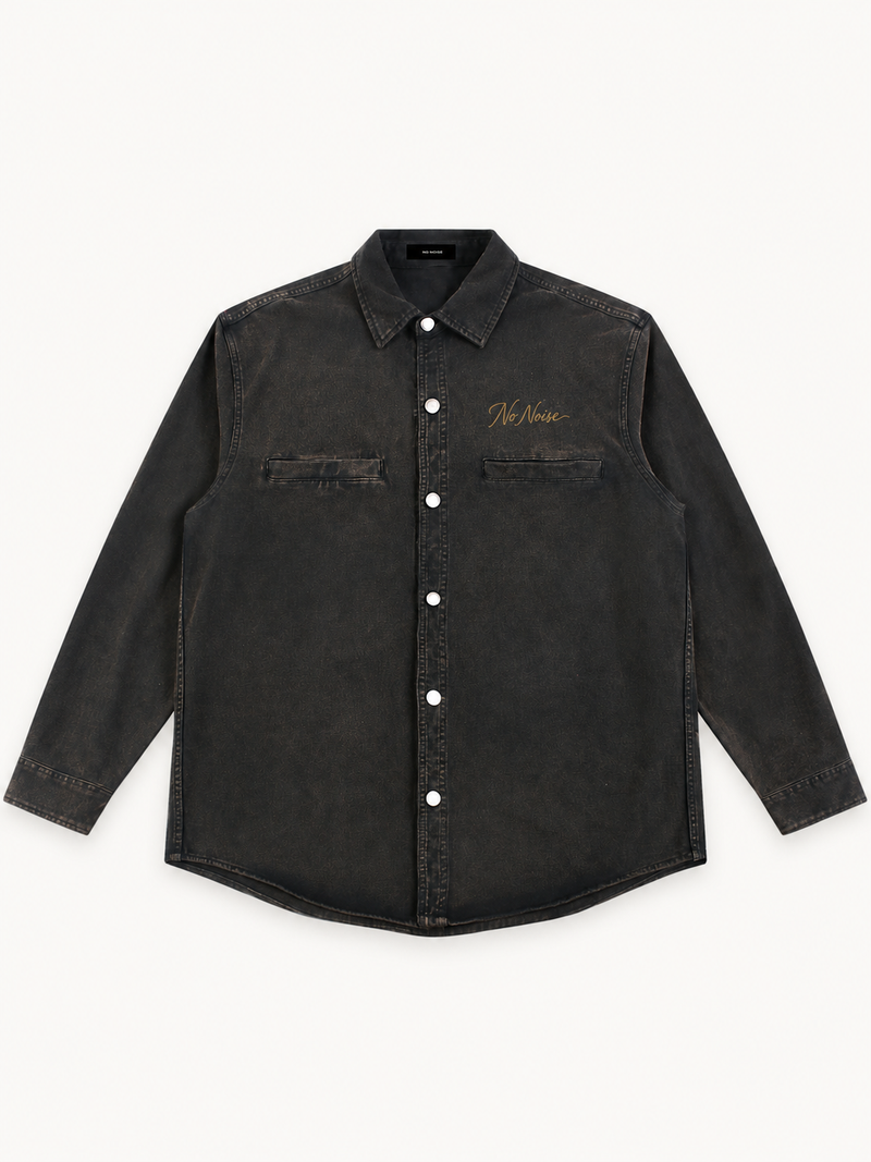NO NOISE Utility Overshirt in washed black, front view showing pointed collar, six silver snaps and two welt chest pockets.