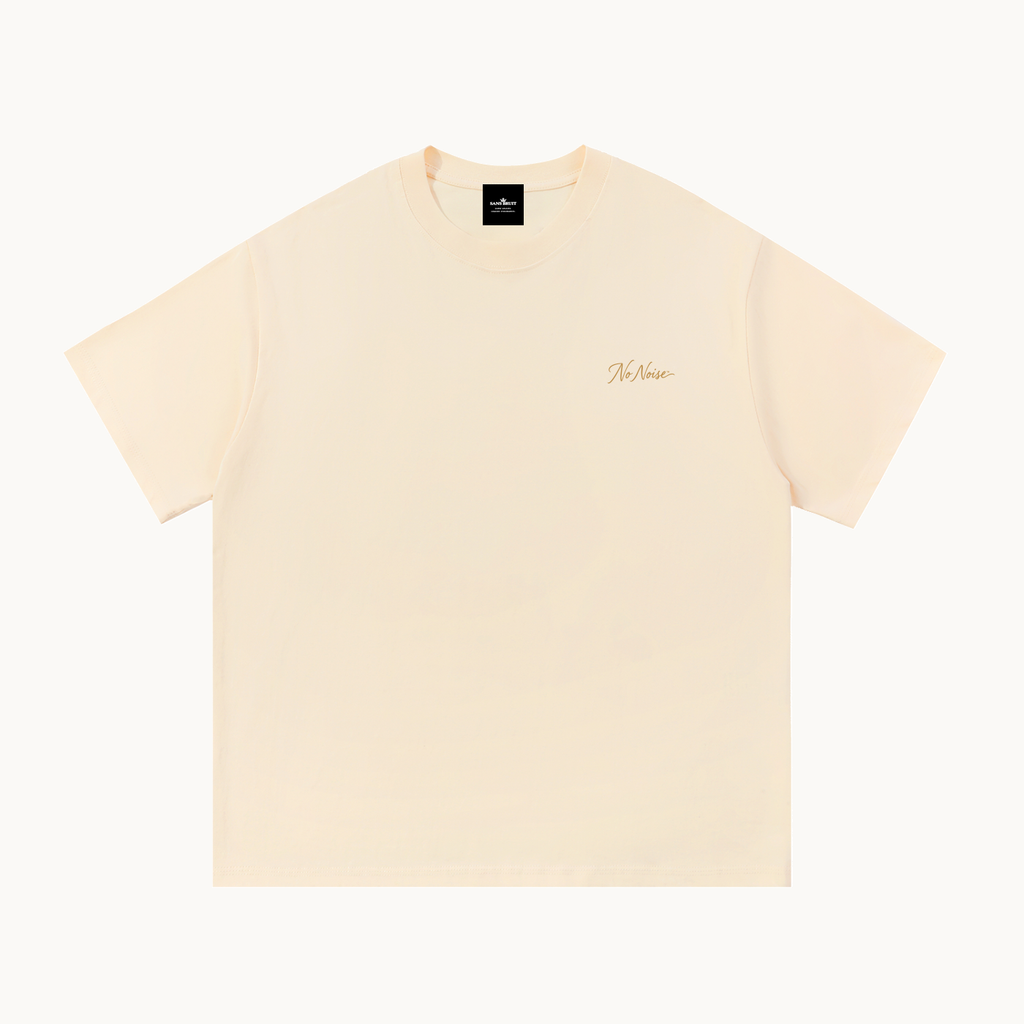 Essential Signature Tee in apricot, front view with small gold No Noise script at the left chest