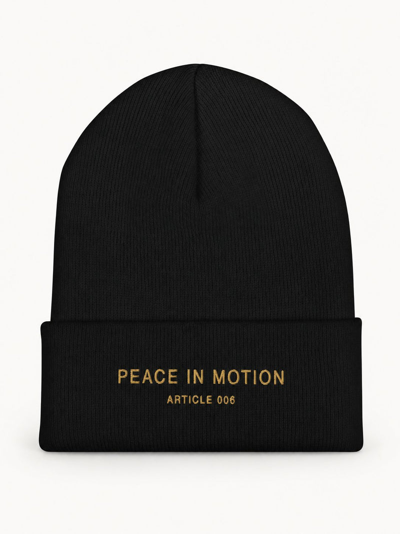 NO NOISE Peace in Motion Cuffed Beanie — Noir, front flat view showing gold PEACE IN MOTION lettering on the cuff.