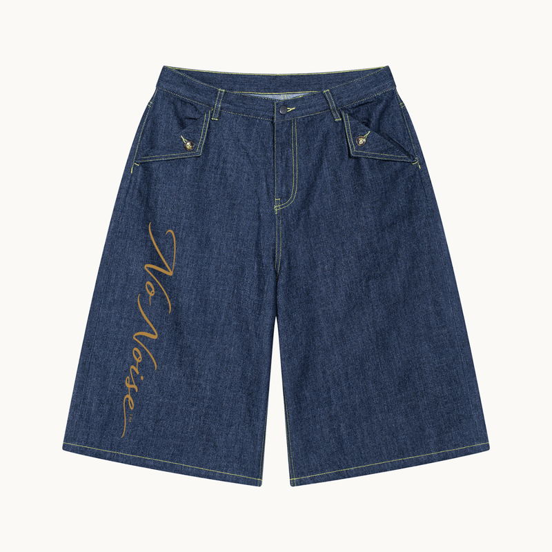 THE SANS BRUIT DENIM BERMUDA — INDIGO — product view on warm ivory.