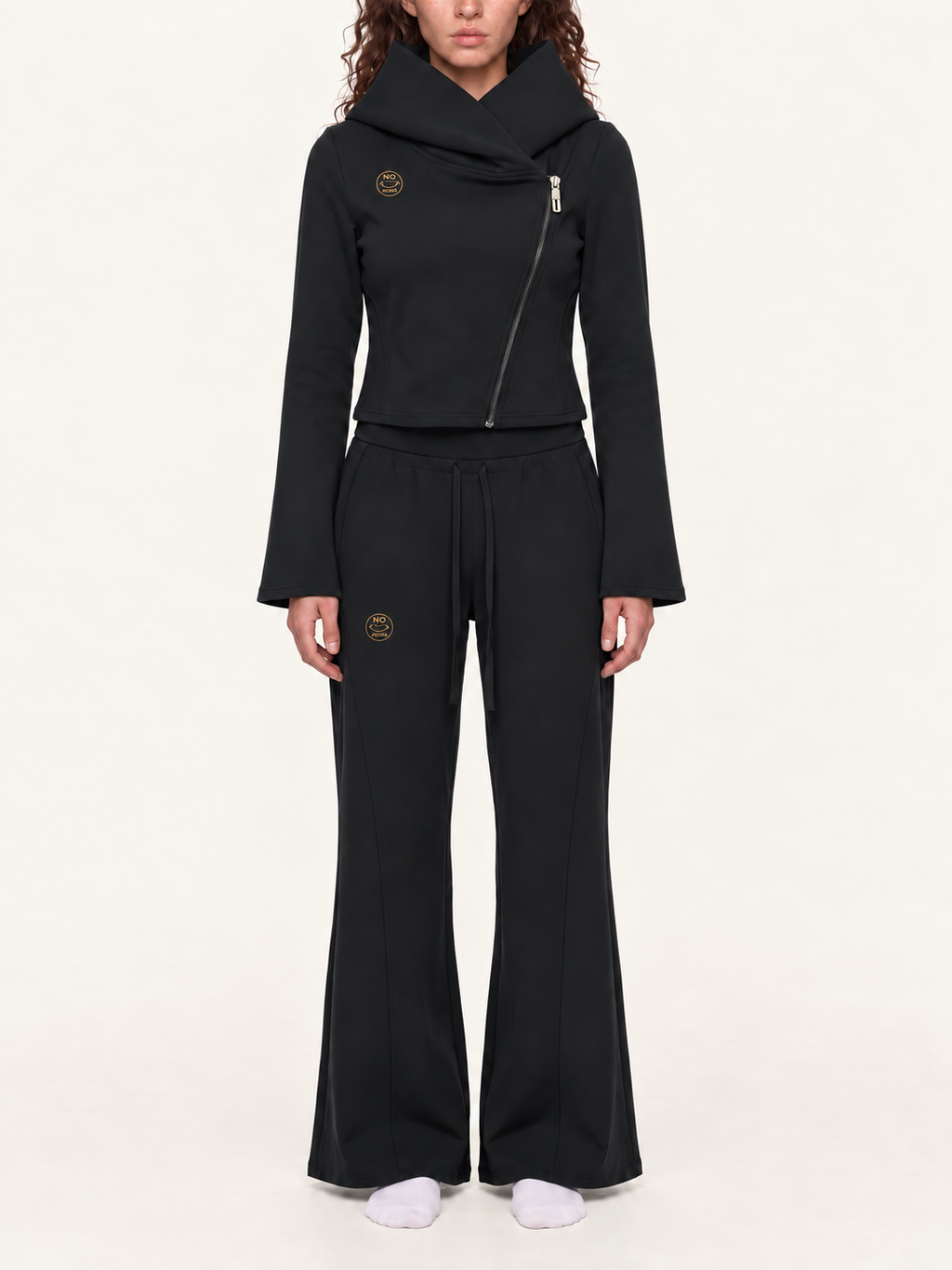 Styling mockup of the black NO NOISE Original Signal asymmetric hoodie and flared pants with matching gold logos.