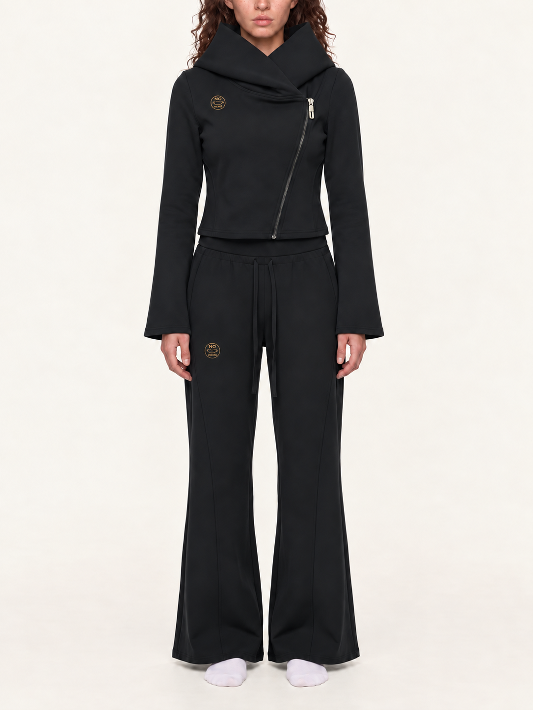 Styling mockup of the black NO NOISE Original Signal asymmetric hoodie and flared pants with matching gold logos.