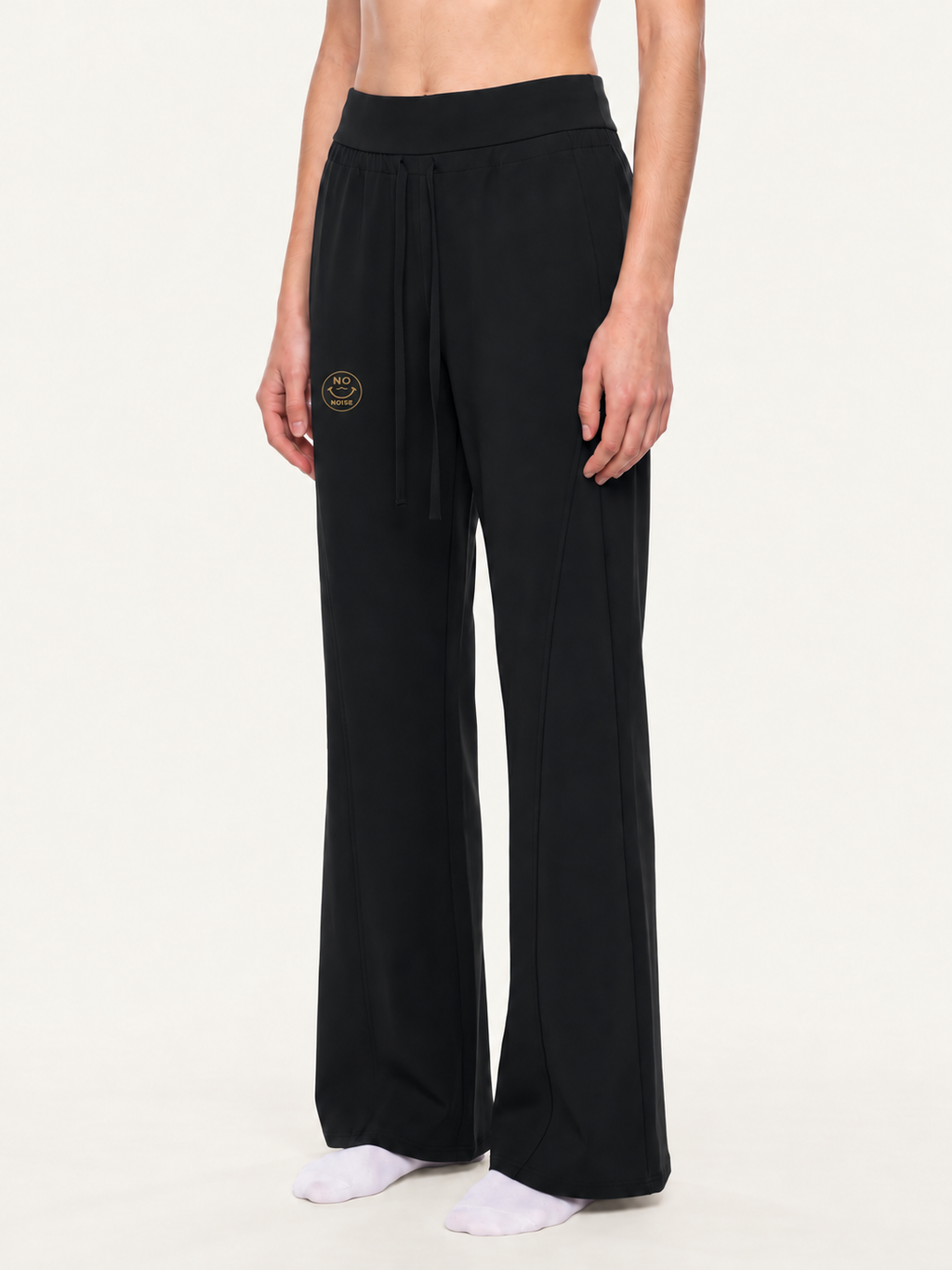 Angled model mockup of black Original Signal flared sweatpants showing drawstrings and gold NO NOISE thigh logo.