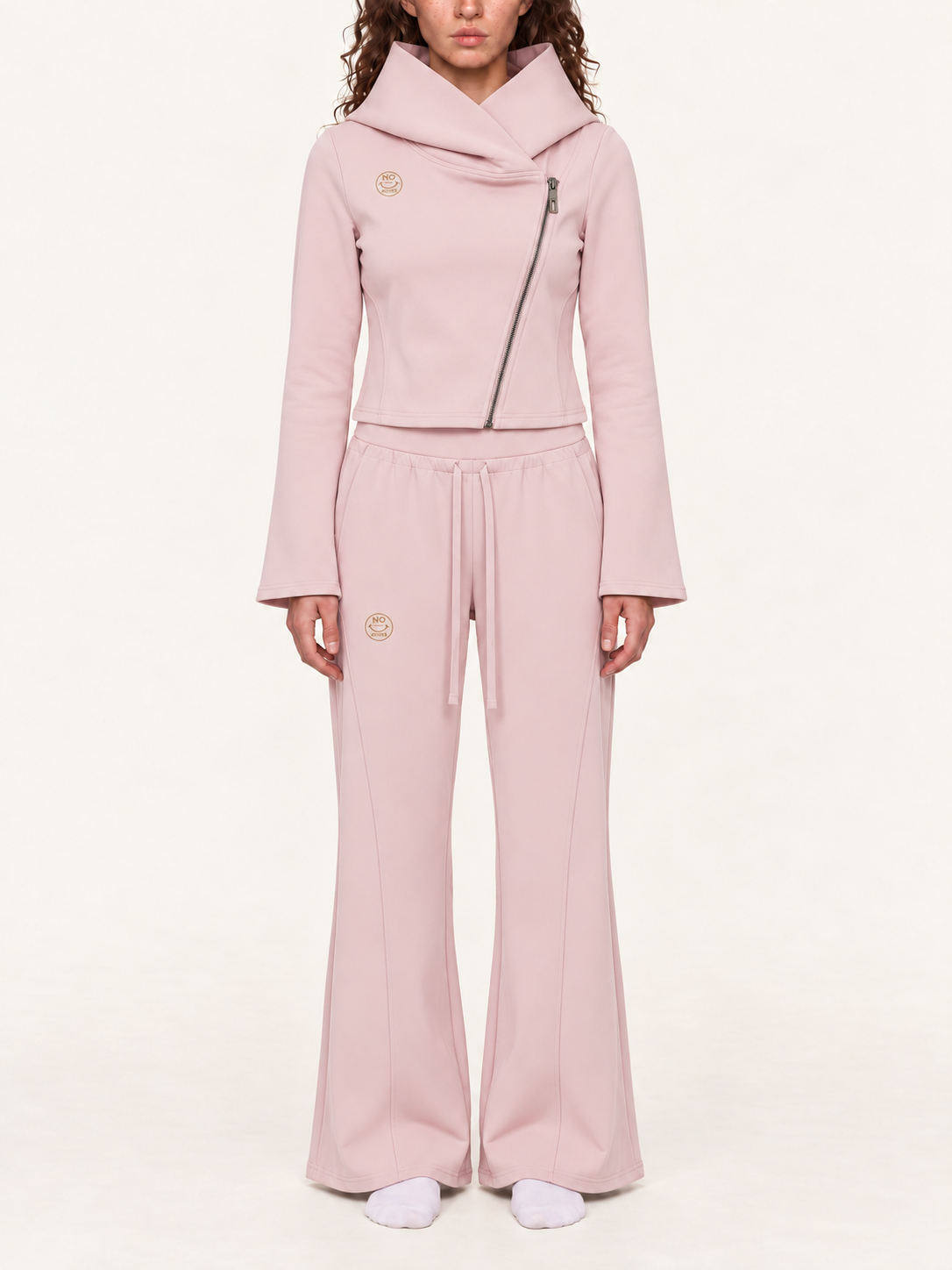 Model mockup of the light pink NO NOISE Original Signal asymmetric zip hoodie and flared sweatpants with matching gold logos.
