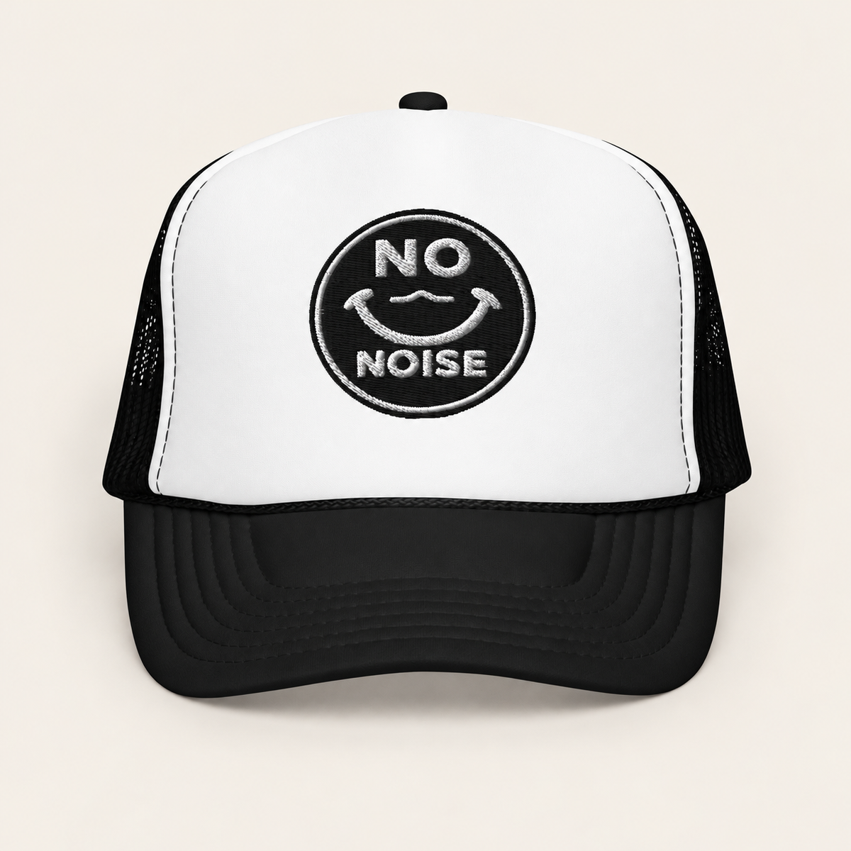 NO NOISE™ Quiet Signal Trucker Hat in black and white on a warm ivory background, front view.
